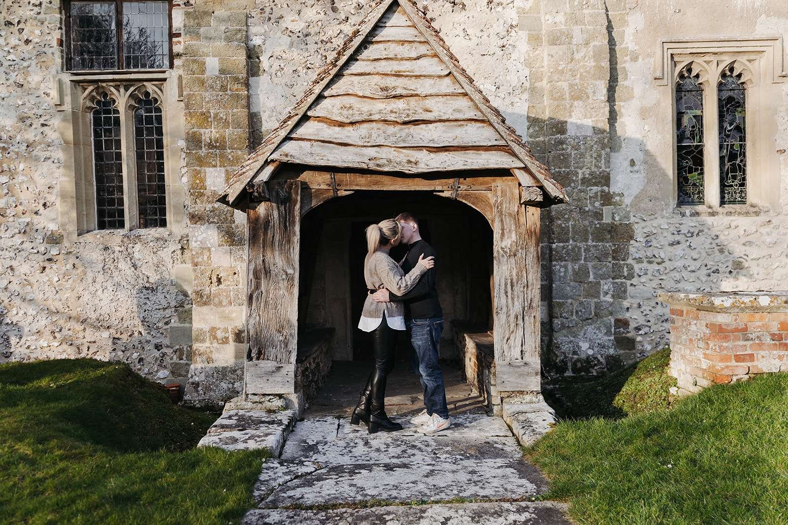 Wedding photographer captures a sweet kiss in front of a picturesque old church