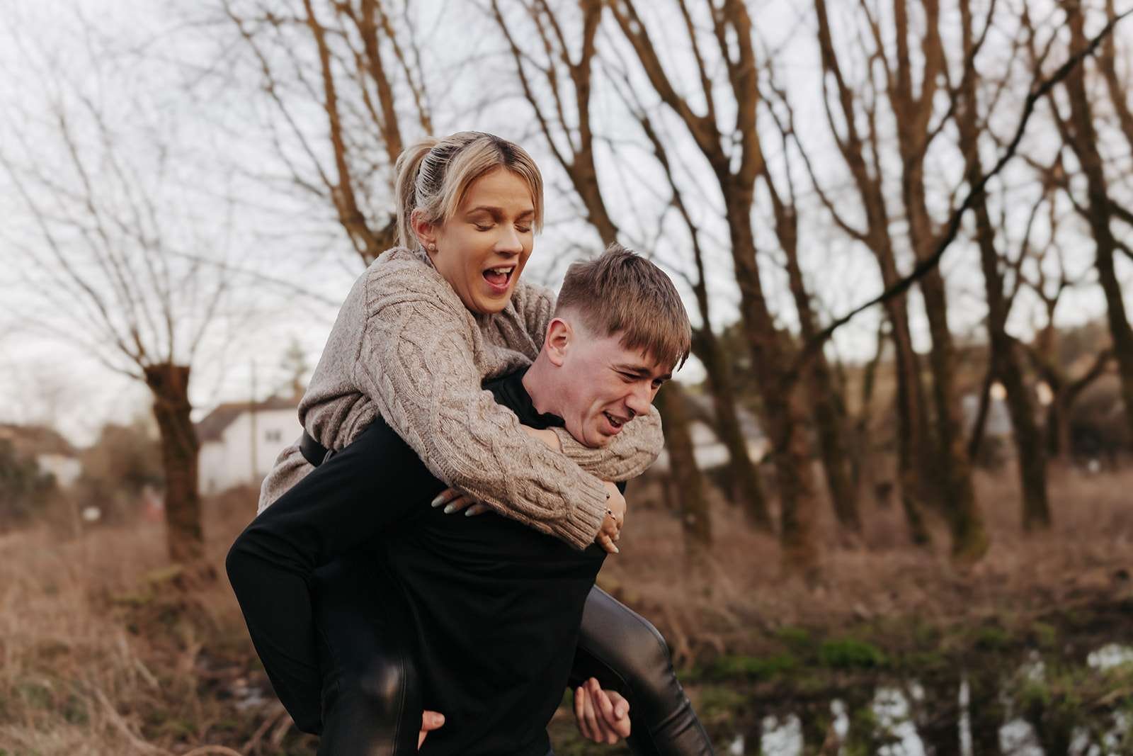 A playful piggyback ride during a couple's engagement photoshoot.